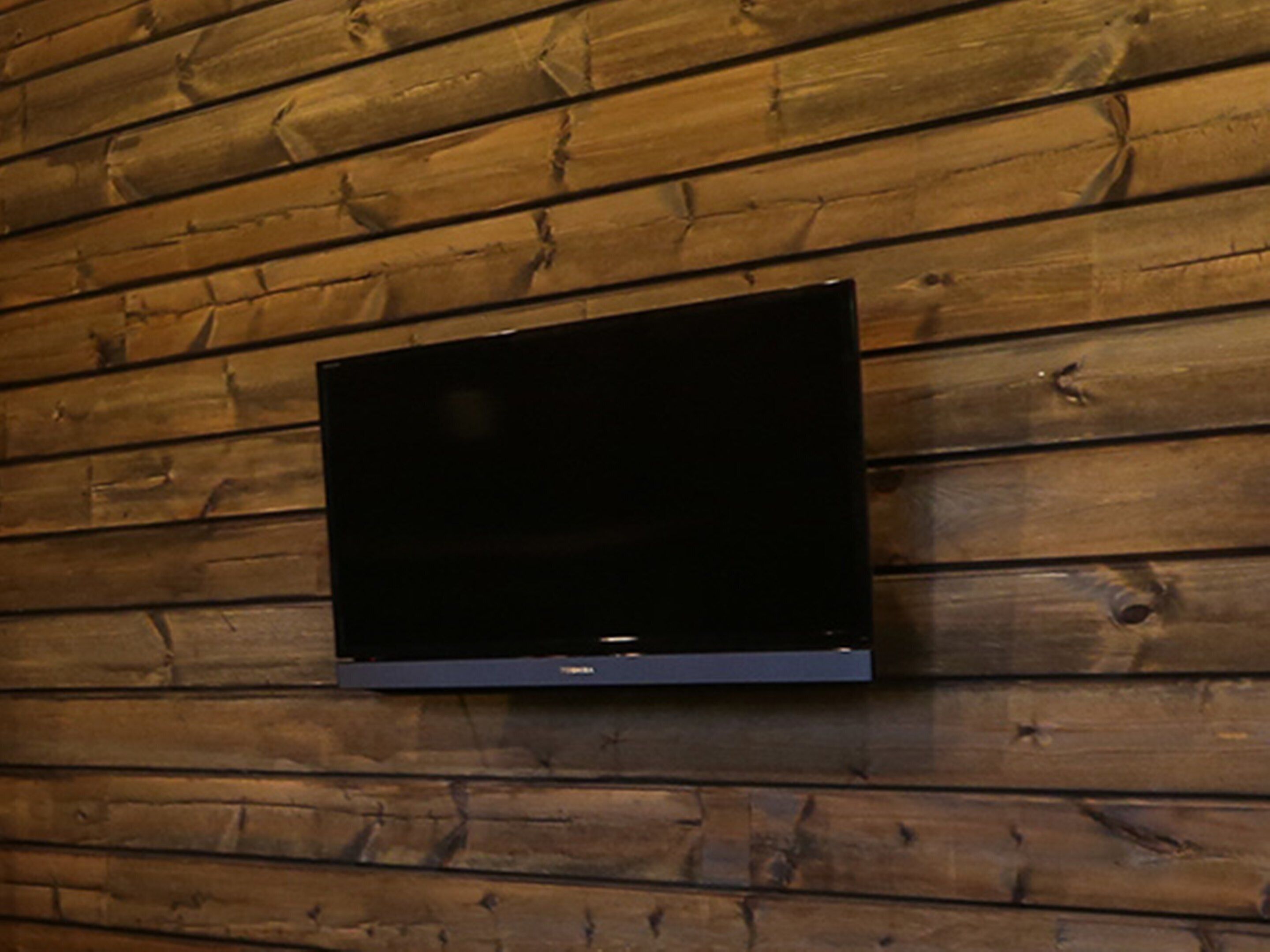 Un televisor de pantalla plana montado en una pared de madera.