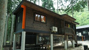 A cabin with a deck, large windows, and an air conditioning unit. - Nagomiya Seseragi (Gujo)