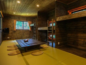 A traditional Japanese-style room with tatami flooring, a low table, and a window with curtains. - Nagomiya Seseragi (Gujo)