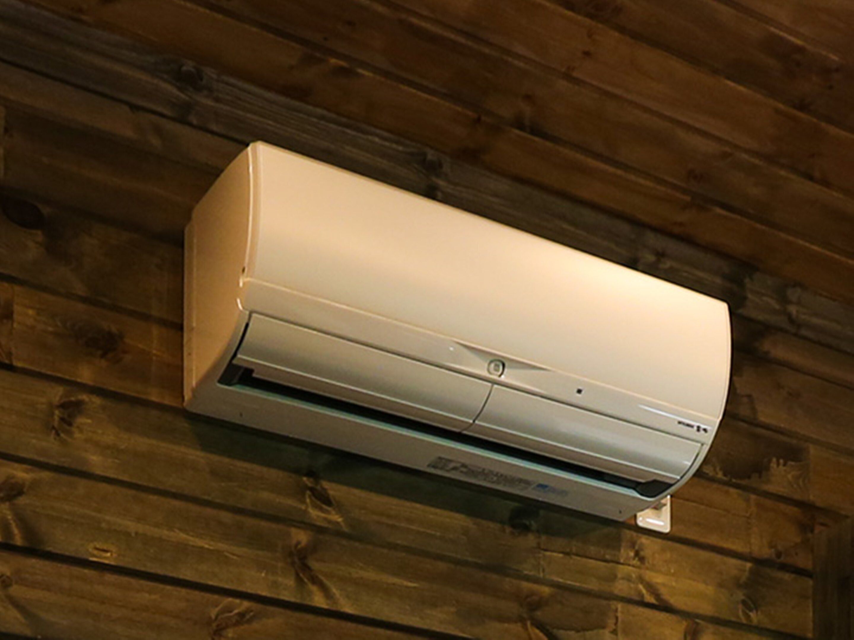 Un equipo de aire acondicionado instalado en una pared de madera.