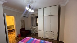 Et soveværelse med seng, garderobe og ventilator i loftet.
