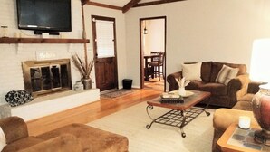 Ein Wohnzimmer mit Kamin, Fernseher und einer Couch.