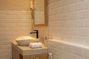 A bathroom with a white sink, a mirror, and a towel. - Serenia Villa by Betterplace (Ubud)