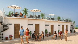 Ein Hotel mit Außenbereich, Blumentöpfen und freiem Blick auf den Strand.