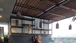 Eine moderne Küche mit Bar, unter einem Holzboden, mit Pendelleuchten und Blick auf die Stadt.