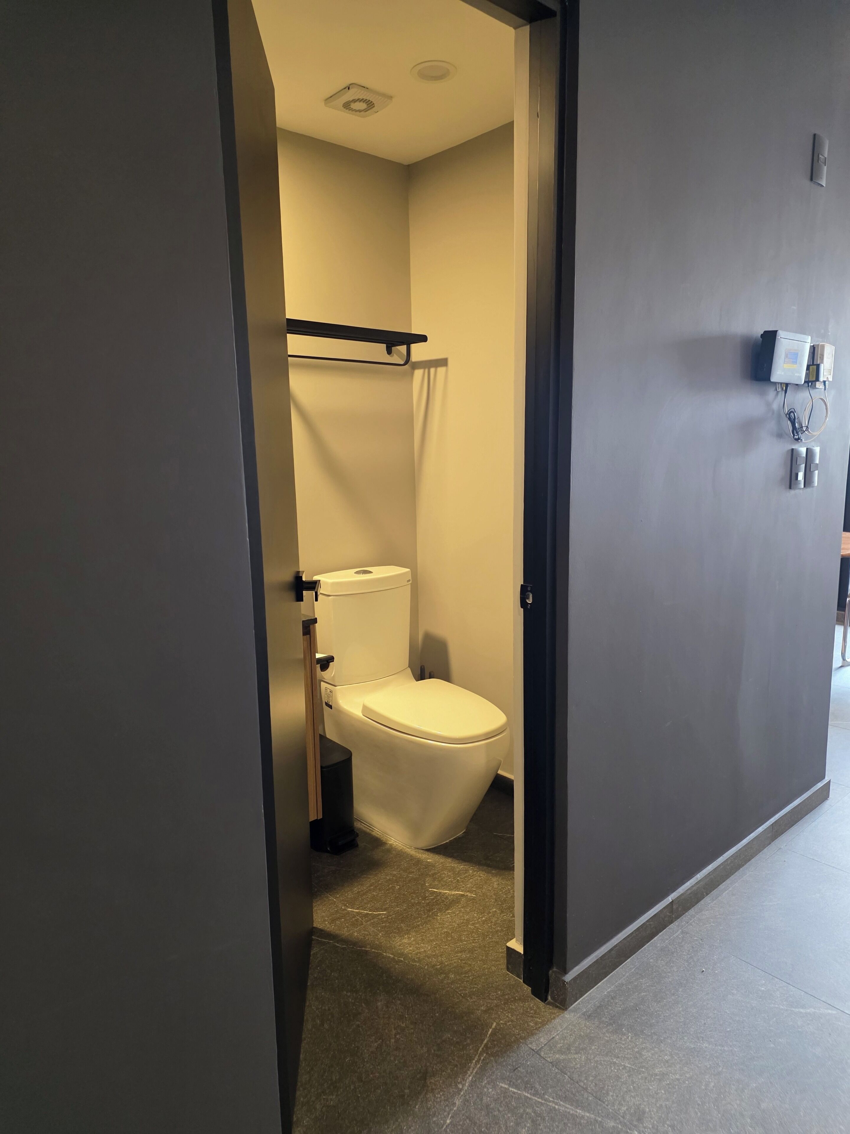 Un baño moderno con inodoro, cortina de ducha y toallero.