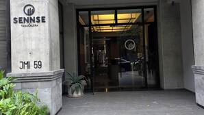 L’entrée d’un immeuble, sur laquelle on peut lire l’inscription « SENNSE TABACALERA » et l’adresse « JMI 59 ».