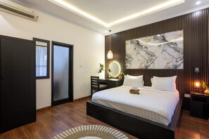 A modern bedroom with a large bed, a bedside table, a mirror, and a wall-mounted artwork. - The Vials Canggu  (Tibubeneng)