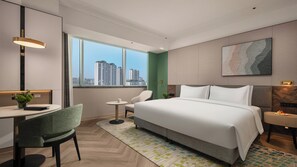 A modern hotel room with a large bed, a desk, a chair, and a view of the cityscape through the window. - Holiday Inn Shijiazhuang High-tech Zone (Shijiazhuang)