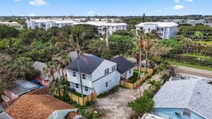 Un barrio residencial con casas blancas, palmeras y cielo despejado.