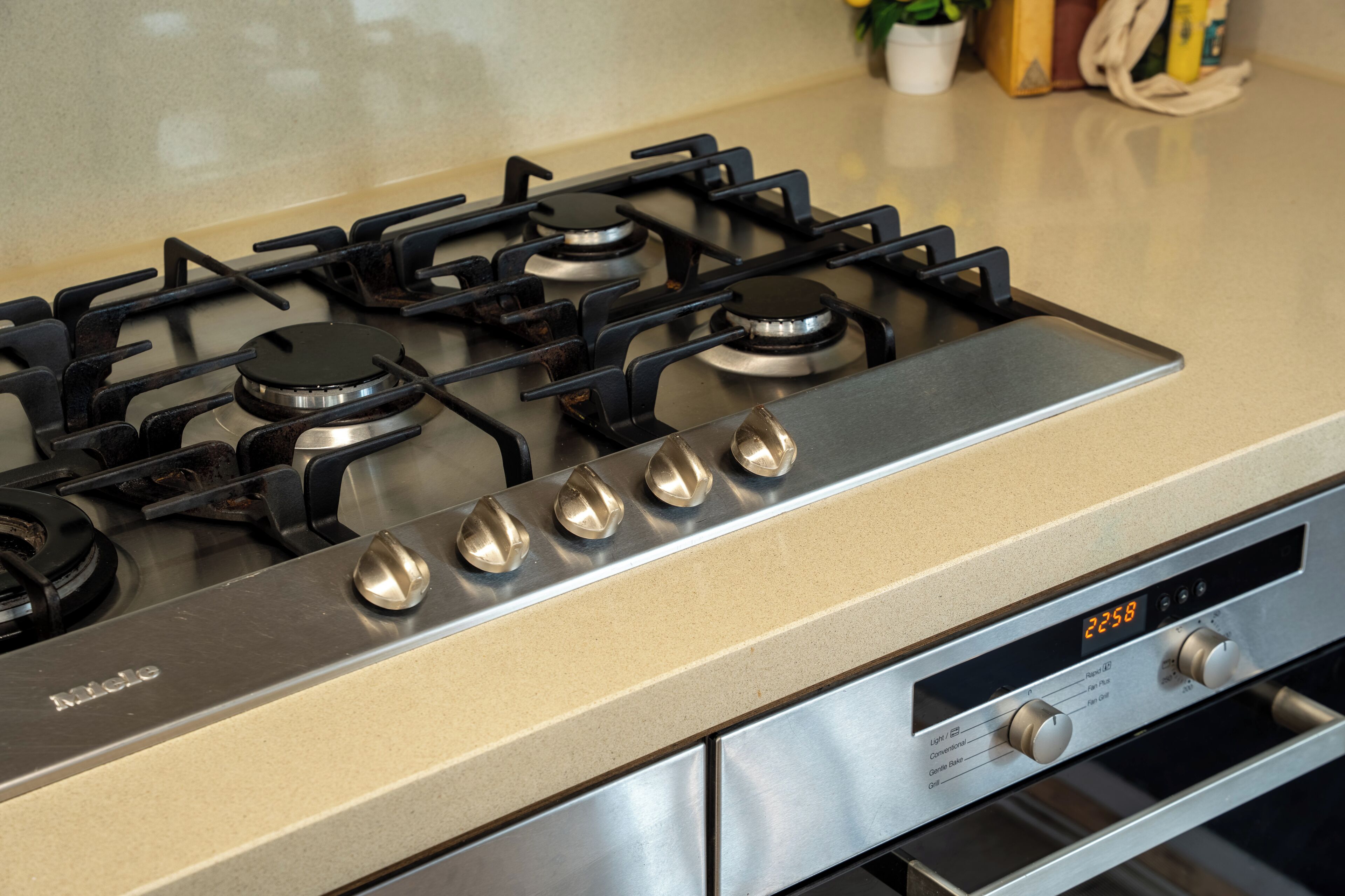 Een keuken met een gasfornuis, oven en bedieningspaneel.