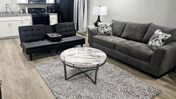 A living room with a sofa, a coffee table, and a lamp.