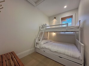 A bunk bed with a ladder, a small window with blinds, and a wooden bench. - Beachfront Luxury Lake Erie *Sleeps 14* HOT TUB. Great for Hosting Groups (Dunnville)