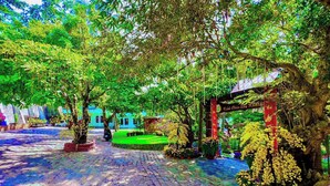 A courtyard with a cobblestone path, potted plants, and a gazebo. - Song Bien Xanh Resort (Mui Ne)
