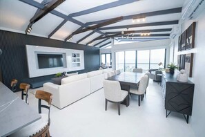 Ein modernes Interieur mit Essbereich, Sofa und großem Fenster.