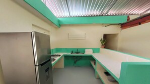 A compact kitchen with a refrigerator, stove, sink, and a potted plant. - Turquesa Bacalar Centro (Bacalar)