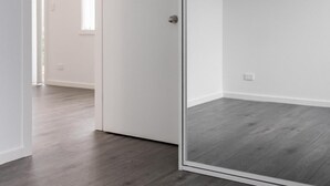 A room with a wooden floor, a white door, and a glass partition. - Luxury Granny Cottage Retreat in arms reach of Golf Course (Wilton)