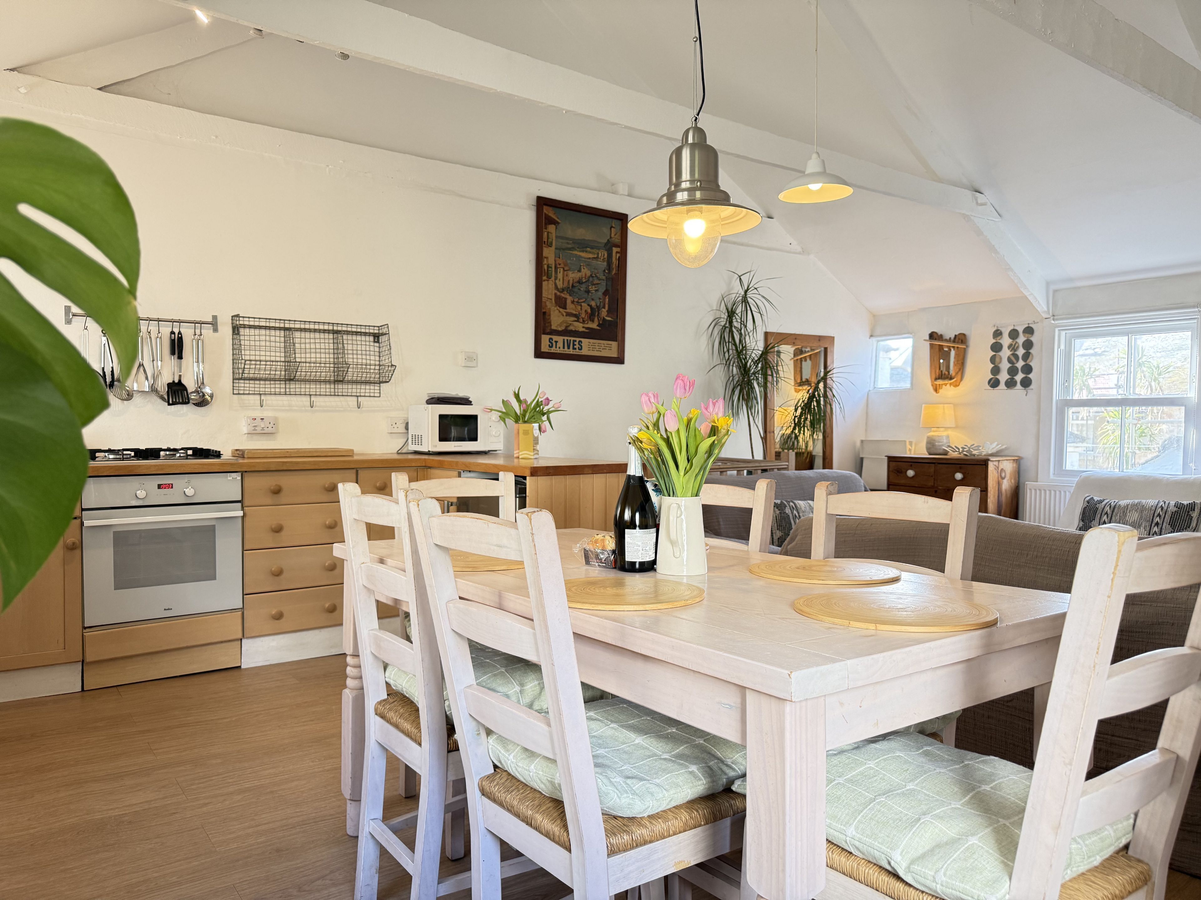 Une cuisine équipée d’une table à manger, de chaises, d’une cuisinière et d’un four à micro-ondes.
