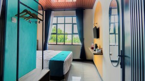 A room with a bed, a window with curtains, a sink, and a mirror. - INSTAY Hotel Dieng Chill Serenity (Garung)