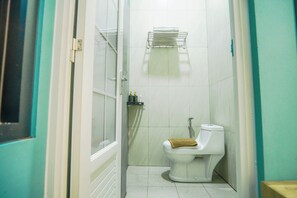 Un baño con inodoro, toallero y zona de ducha.