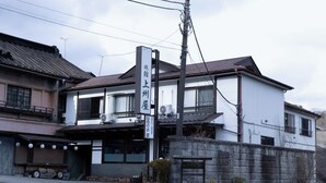En toetages bygning med et skilt, der viser 'Yoshida Inn'.