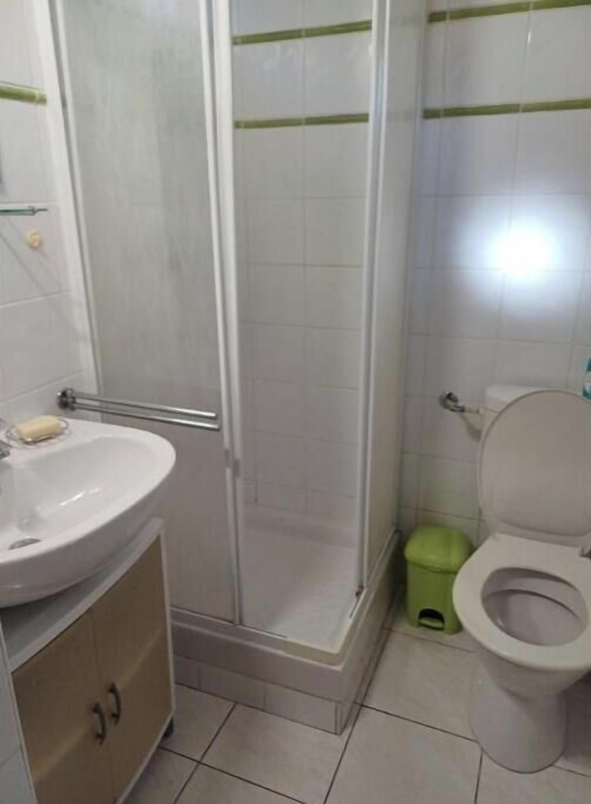 A bathroom with a sink, toilet, and shower.