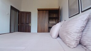 Een slaapkamer met een bed, een kledingkast en een deur.