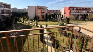 A residential complex with multiple apartment buildings, a well-maintained lawn, and a clear sky. - Cozy Sea Style Studio with Balcony (Sunny Beach)