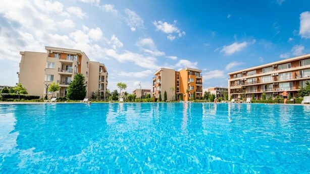 A swimming pool with adjacent multi-story residential buildings. - Cozy Sea Style Studio with Balcony (Sunny Beach)