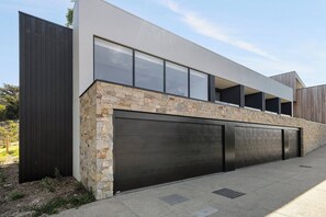 A modern two-story house with a stone facade, large windows, and a garage. - Luxury Villas Blairgowrie Hideaway (Blairgowrie)