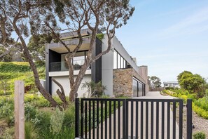 A modern two-story house with a stone facade, large windows, and a black gate. - Blairgowrie Hideaway with gym (Blairgowrie)