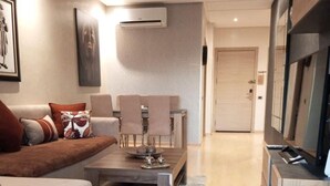 A modern living room with a sofa, coffee table, and TV stand. - Apartment Prestigia Jade pool and garden view (Marrakech)