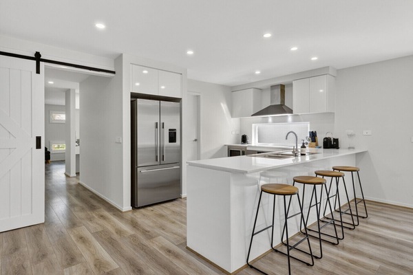 Modern kitchen with island bench, bar seating, and stainless steel appliances