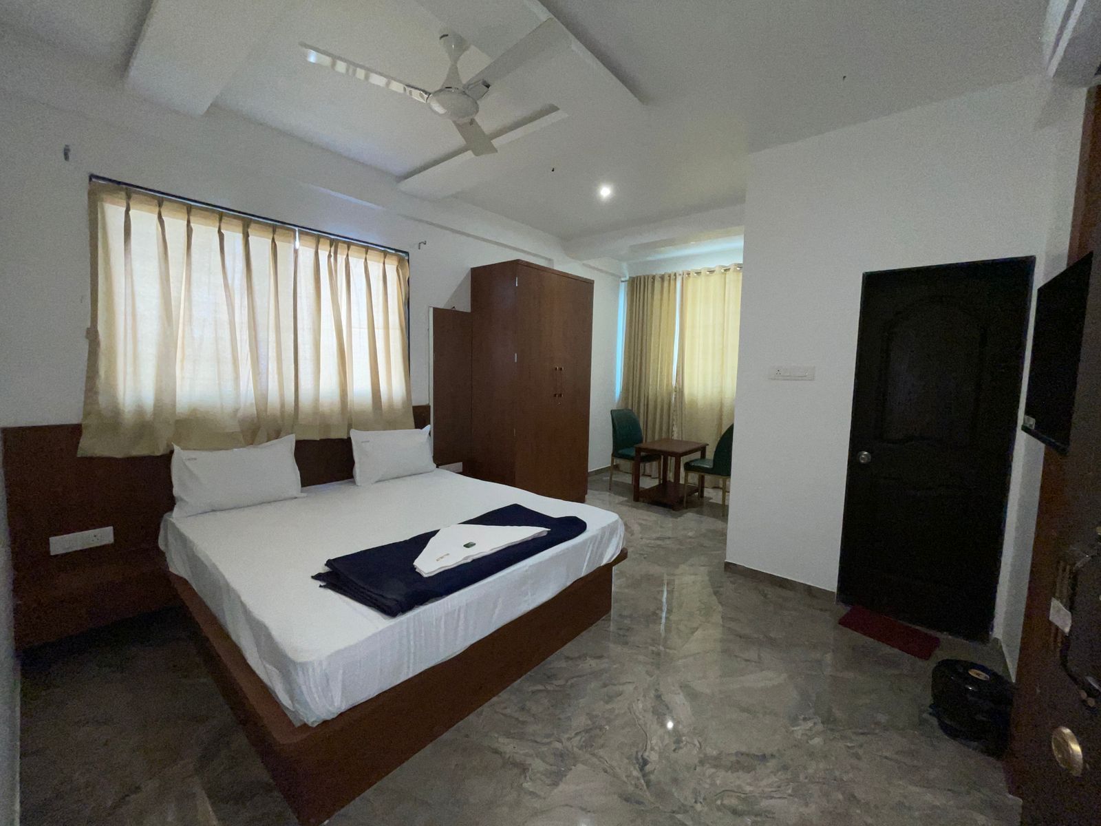 Una habitación de hotel con cama, armario, escritorio y silla.