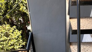 Een trap met metalen leuning die uitkomt op een plateau.