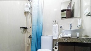 A bathroom with a shower, toilet, sink, and a towel rack. - Manzil Anilao Unit 1 - Ground Floor 1st Room (Mabini)