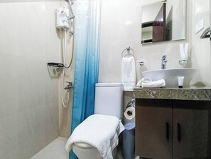 A bathroom with a shower, toilet, sink, and a towel rack. - Manzil Anilao Unit 1 - Ground Floor 1st Room (Mabini)