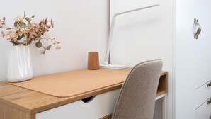 A workspace with a desk, chair, lamp, and a vase with dried flowers. - Vivelorural Casa Marao Great sea Views (Arucas)