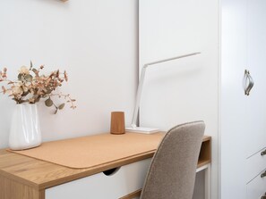 A workspace with a desk, chair, lamp, and a vase with dried flowers. - Vivelorural Casa Marao Great sea Views (Arucas)