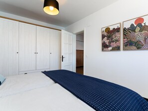 A bedroom with a bed, a wardrobe, and two wall-mounted artworks. - Vivelorural Sunrise in La Garita (Telde)