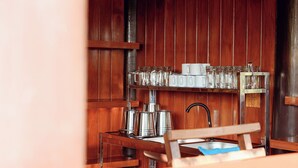 A wooden interior with a metal shelf holding glassware and a kettle. - Le Ping Villas (Kao Liao)