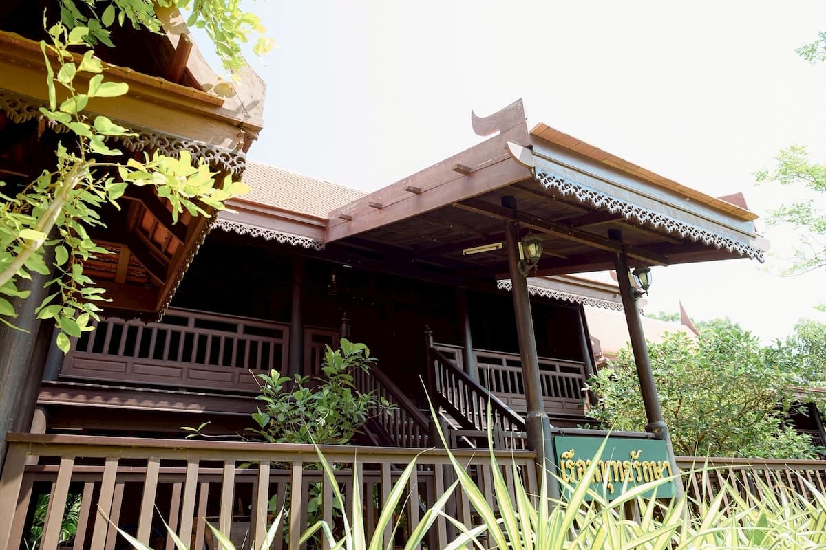 Un bâtiment traditionnel en bois, doté d’un balcon, d’un escalier et d’une enseigne.