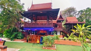 A traditional wooden structure with a balcony, a bar area, and a small stage with musical instruments. - Le Ping Villas (Kao Liao)