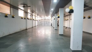 A spacious indoor area with a high ceiling, columns, and a tiled floor. - Asha heritage Hotel & Restro (Haridwar)