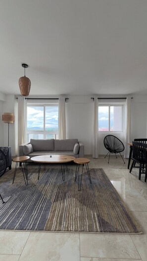 A modern living room with a sofa, coffee table, chairs, and a rug. - Luxurious 3-Bedroom Apartment in Westlands, Nairobi (Nairobi)