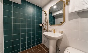 A bathroom with teal tiles, a white sink, a gold faucet, and a mirror with a gold frame. - No. 25 Hotel Sinchon (Seoul)