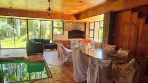 A spacious room with a pool, a fireplace, and large windows. - Luxurious Beachfront B&B in East London, South Africa (East London)