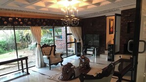 Un salón espacioso con un gran ventanal, chimenea y una araña.