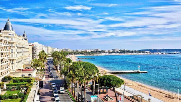 Un paisaje urbano costero con un hotel destacado, una playa y un cielo azul despejado.
