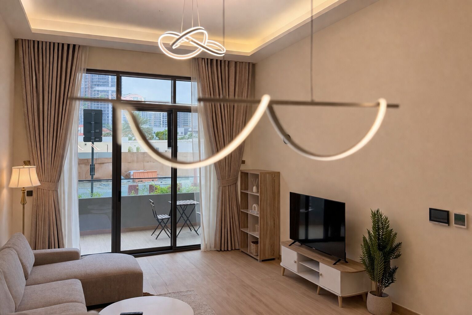 Un salon moderne avec un canapé, un téléviseur et un balcon agrémenté de rideaux.